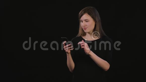 一位女士在黑色背景下使用电话视频的预览图