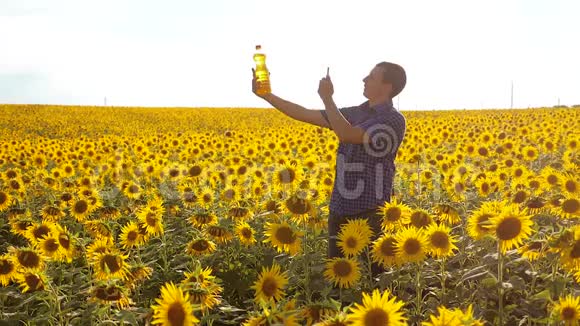 男子农民探索田野与向日葵生活方式慢动作视频男人的生活方式农民手拿瓶子视频的预览图