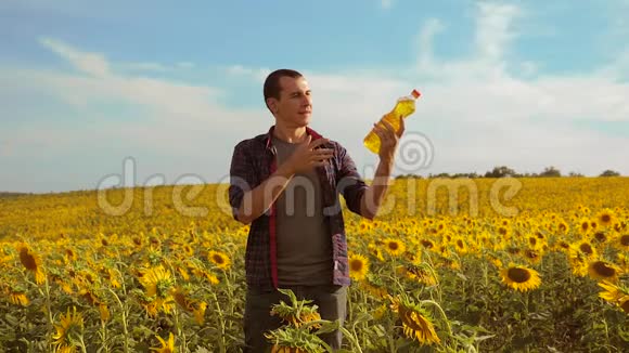 日落时分农夫手里拿着一瓶向日葵的生活方式给田野加油慢动作视频农民农业视频的预览图