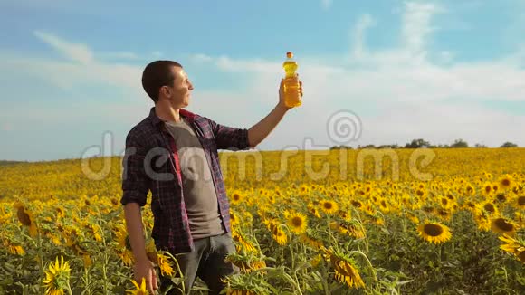 日落时分农夫手捧一瓶葵花籽油农民农业塑料瓶葵视频的预览图