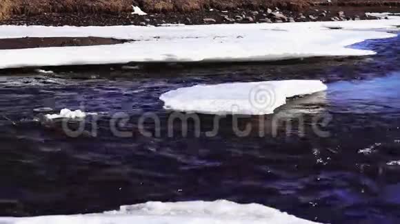 阳光明媚的春天里河流在冰中流动视频的预览图