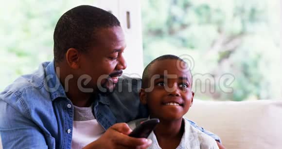 儿子和父亲在客厅看电视视频的预览图