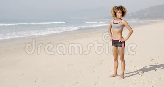 运动女站在海滩上视频的预览图