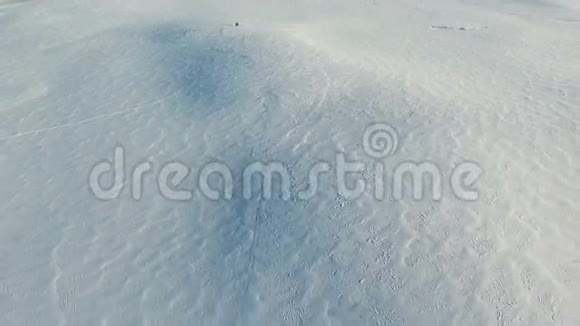 冬季雪场上空飞行和起飞空中全景雪的图案和质感视频的预览图
