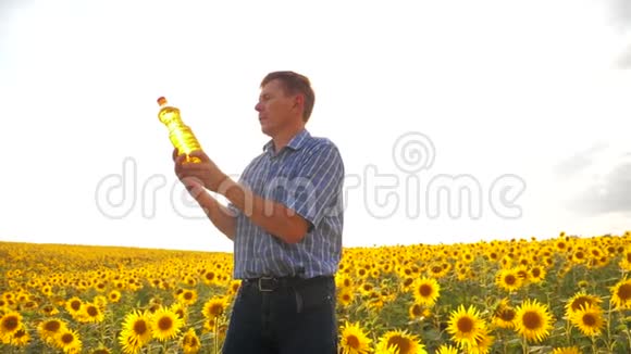 老人阳光农夫葵花油概念农业农夫手里拿着一个塑料瓶葵花籽油视频的预览图