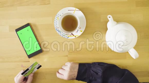 女性手在平板电脑上滚动着绿色屏幕视频的预览图