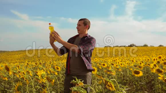 日落时分农夫手捧一瓶葵花籽油的生活方式慢动作视频农民农业视频的预览图