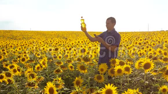 农夫用向日葵在田野里探索慢生活方式运动视频男人的生活方式农民手拿瓶子视频的预览图