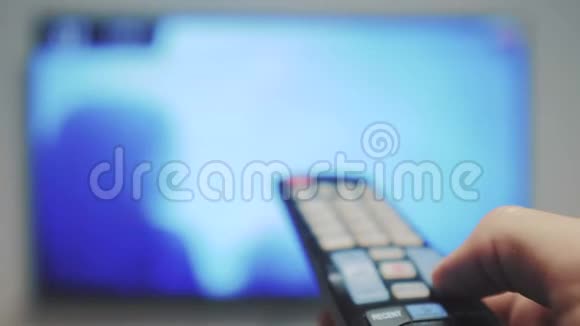 人手握电视遥控器关掉智能电视频道冲浪亲密的男人手拿着电视视频的预览图