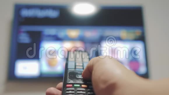 智能电视与应用程序和手工生活方式男性手握遥控器关闭智能电视生活方式手视频的预览图