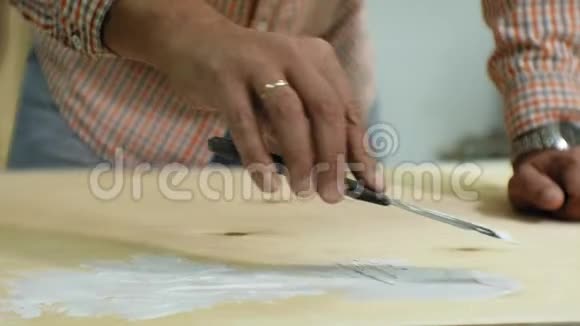 大师在艺术工作室用油漆和腻子处理木材达到老化效果视频的预览图