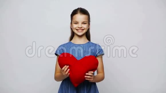 快乐的微笑女孩红色心形枕头视频的预览图