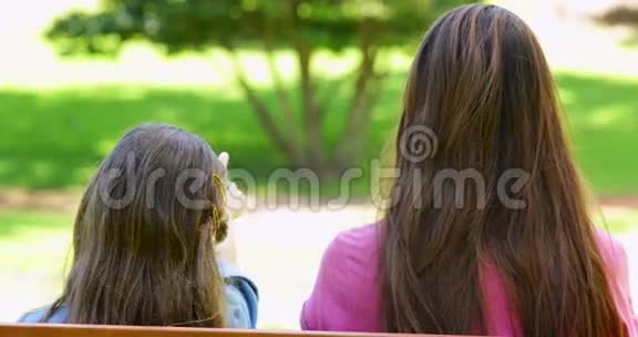 母女俩坐在公园的长椅上视频的预览图