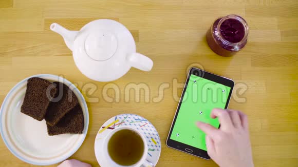 绿色屏幕女性手滚动平板电脑视频的预览图