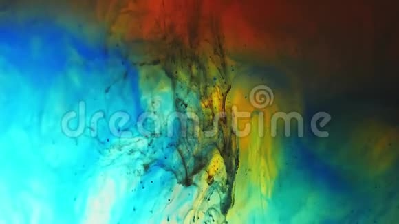 五颜六色的彩虹油漆从底部滴在水中混合特写镜头视频的预览图