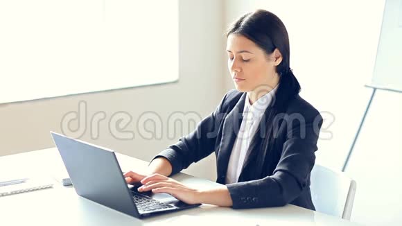 漂亮的商务女性在办公室用笔记本电脑工作视频的预览图