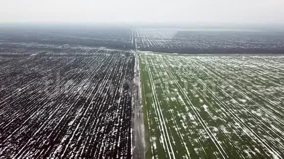春天空中景色中被雪覆盖的粮田视频的预览图