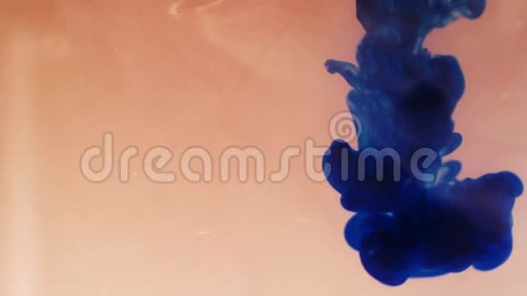 五颜六色的彩虹油漆从底部滴在水中混合特写镜头视频的预览图