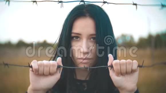 女孩黑发难民背后铁丝网营地慢动作视频自由的概念令人不安视频的预览图