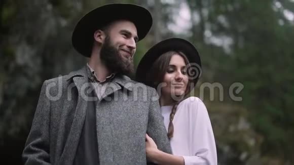 时髦的时髦夫妇温柔的拥抱波赫吉普赛女人和戴帽子的男人拥抱她乡村时尚的外观山脉视频的预览图