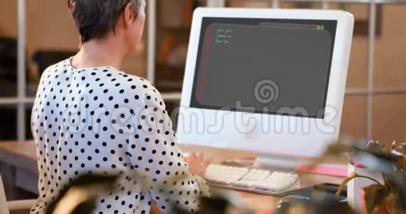 办公桌上电脑工作的女主管的后视图视频的预览图