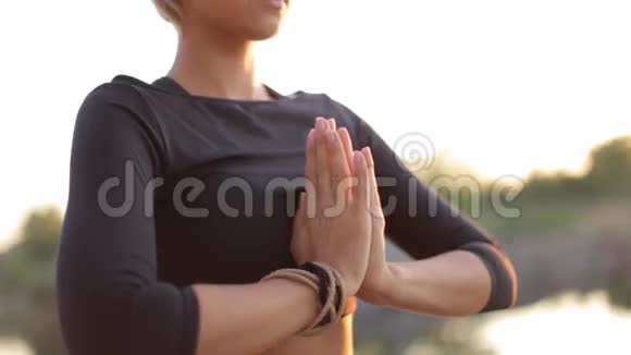 太阳落山时坐在莲花的位置上的运动女孩视频的预览图