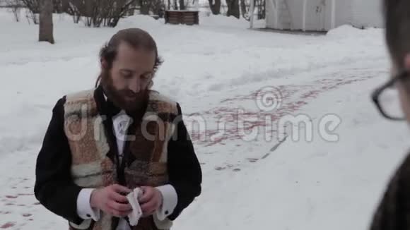 穿着西装戴着领结的长胡子男人在冬天的背景下视频的预览图