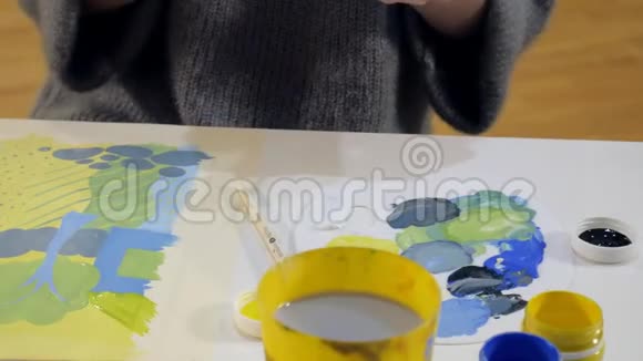 在一所艺术学校里成年女性用彩色丙烯酸颜料作画视频的预览图