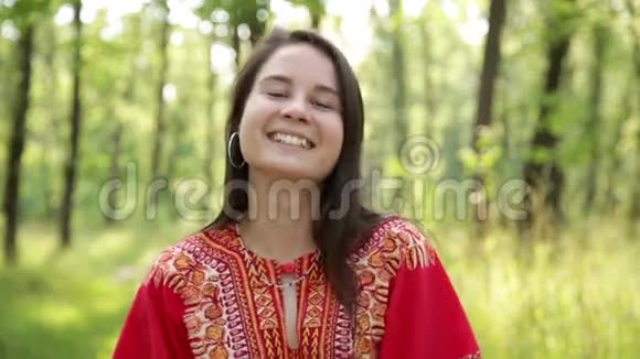 美丽的女孩穿着红色的裙子微笑视频的预览图