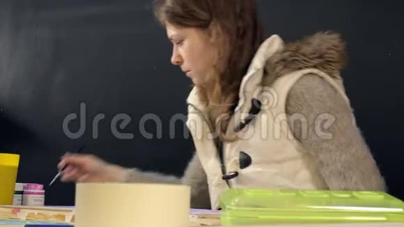 成人妇女在艺术学校用彩色丙烯酸涂料作画视频的预览图