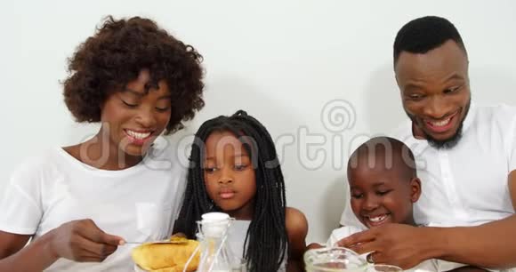 幸福的家庭一起在床上吃早餐视频的预览图