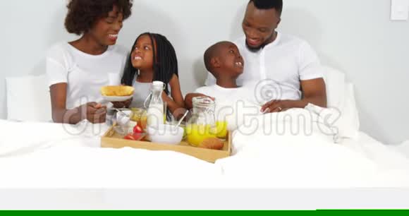 幸福的家庭一起在床上吃早餐视频的预览图