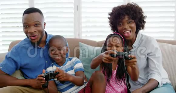 一家人坐在沙发上玩电子游戏视频的预览图