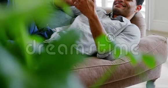 快乐男人在客厅用手机视频的预览图