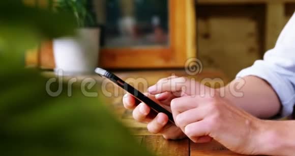 坐在桌子上的男人用手机视频的预览图