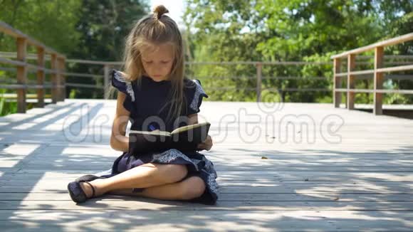 可爱的小女孩带着笔记和铅笔在户外回学校去视频的预览图