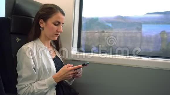 一位年轻女士在火车上使用智能手机视频的预览图