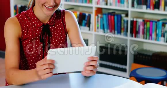 在图书馆使用数码平板电脑的女学生视频的预览图