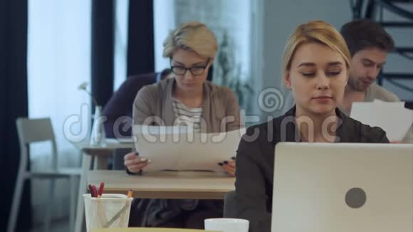 在现代办公室用笔记本电脑工作的年轻女性视频的预览图