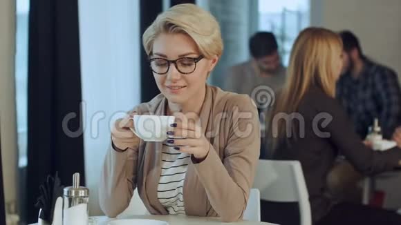在咖啡馆喝咖啡的年轻美女视频的预览图