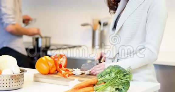 女人在厨房切菜时互动视频的预览图