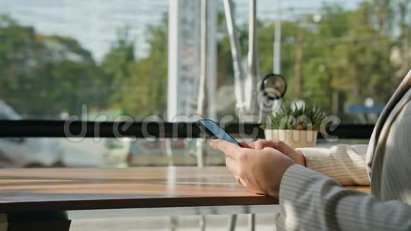 一位年轻女士在咖啡厅里用智能手机视频的预览图