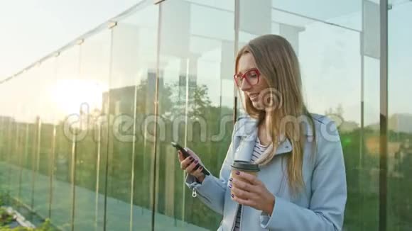 一位年轻的女士走路和使用电话门视频的预览图