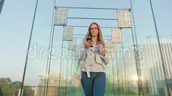 一位年轻的女士走路和使用电话视频的预览图