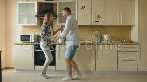 快乐的年轻快乐的夫妻在家厨房做饭的时候玩得开心视频的预览图