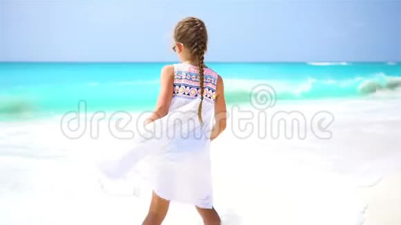 加勒比海度假期间可爱的小女孩在海滩上散步视频的预览图