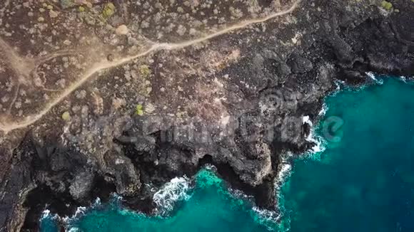 无人的海岸的俯视图特内里费岛的岩石海岸空中无人机的海浪到达海岸的画面视频的预览图