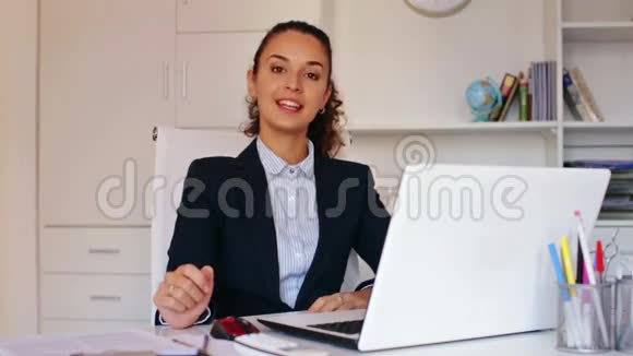 商务女士坐在办公桌前视频的预览图