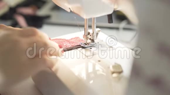 在缝纫机上工作的女性手的特写镜头年轻女性概念设计师在家里做缝纫机时尚视频的预览图