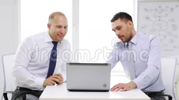 两个带着笔记本电脑微笑的商人视频的预览图